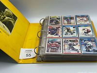 yellow binder open showing nine hockey cards in plastic sheet