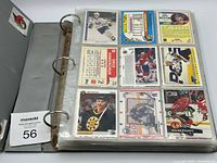Grey binder open showing nine hockey cards in plastic sheet