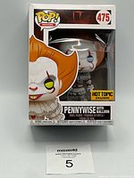 Front view of boxed Pennywise Funko Pop showing figure, Hot Topic Exclusive sticker, number 475