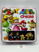 Front of metal tin showing Super Mario Chess graphics and viewing window with sample pieces