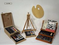 Overall view showing easel, two art boxes, palette and books