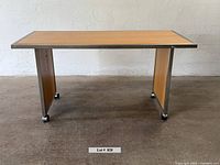 Front view of rectangular wood & metal table on casters