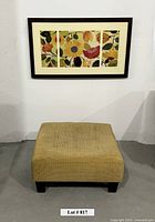 Framed floral artwork above square ottoman front view