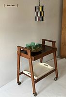Angled view showing bar cart, lazy susan with glasses, hanging stained glass light