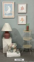 Overall lot showing sheet set, lamp, plant stand, three framed prints, glass vases