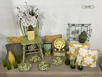 Group shot of all items including pillows, chair, plates, glasses, lantern, tray, vase with flowers, Mancala game, candles, etc.