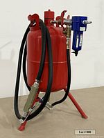 Full view of red pressurized blaster tank with hose, separator and nozzle