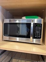 Front view of stainless Danby Designer microwave on shelf
