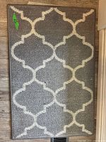 Full view of gray rug with ivory trellis pattern