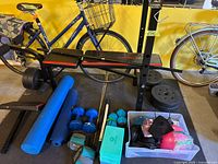 Full view of bench, barbell, plates, dumbbells, mats and accessory bin