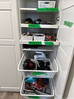 Cabinet shelves showing baskets of sunglasses, belts, and bags