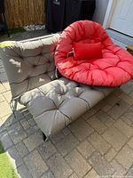 Front view of loveseat with gray cushions and red papasan cushion on top