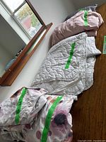 Floral duvet cover, white quilted coverlet, pink and gray sheet sets on bed surface