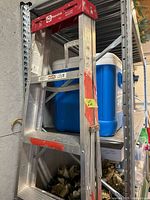 Front view of Reynolds aluminum step ladder showing red top and paint splatters