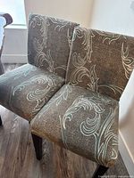 Two chairs with patterned slipcovers, showing overall design and legs