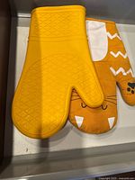 Top view of both mitts displaying silicone texture and cat design