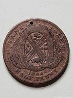 Obverse of token showing shield design, date 1844, and hole at top