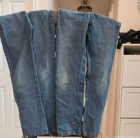 Front view of both pairs of blue denim jeans hanging side by side