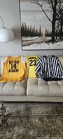 Three jerseys laid out on sofa showing fronts