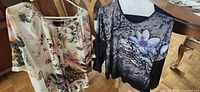 Both printed women's tops hanging on hangers