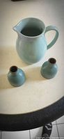 Pitcher and two matching bud vases on tabletop