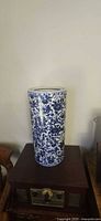Full view of blue and white cylindrical vase on table