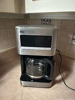 Front view of Braun drip coffee maker with carafe showing control panel and carafe