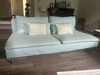 Front view of light blue two-seat sofa with cushions