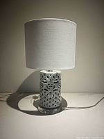Front view of lamp showing shade and ceramic lattice base