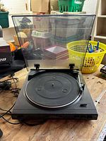 Front corner view of Optimus turntable with lid open showing platter and tonearm