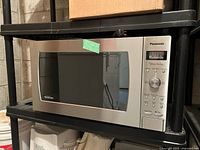 Front view of Panasonic stainless steel microwave on shelf