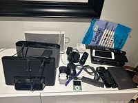 Front view of all electronics including speaker docks, phones, mice, streaming sticks, AirPods, iPod, Kobo, Bell box, MacBook case package