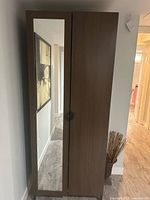 Front view of closed wardrobe showing mirrored left door