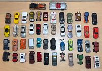 All 50 loose diecast cars spread in rows on tabletop