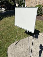 Dry erase board mounted on silver metal easel outside