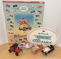 Poster, oval sign and four Kiddie Car Classics models grouped