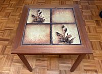 Angled view of teak end table showing four tiled top