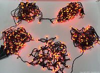 Five coiled strands of orange string lights displayed