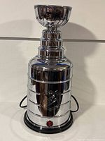 Front view of popcorn popper showing chrome trophy body and power button