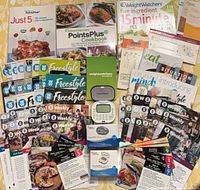 All items laid out including cookbooks, calculators, pedometer, cards and booklets