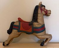 Front view of wooden carousel horse plaque showing painted details and overall appearance