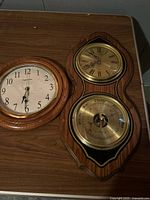 Ingram wall clock and Bulova weather station side by side on table