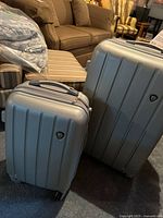 Both suitcases front view showing size difference and overall condition