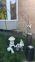 full view of trellises, solar lights, figurines on grass