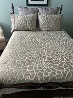 Comforter covering double bed, floral pattern visible
