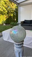 Close view of iridescent mosaic gazing ball on pedestal