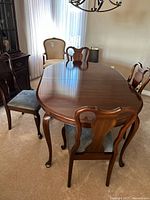 Mahogany dining table with four chairs arranged around it