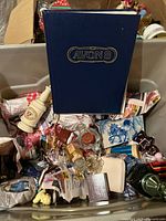 Overview of tub with Avon book, multiple perfume bottles, packaging