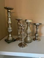 Group of mercury glass candle holders showing both heights