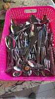Basket full of mixed stainless flatware pieces